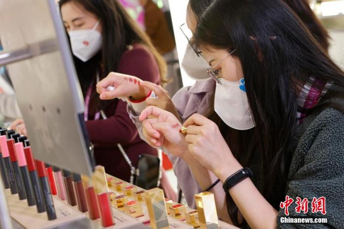 圖為女生正在體驗口紅產(chǎn)品。 殷立勤 攝